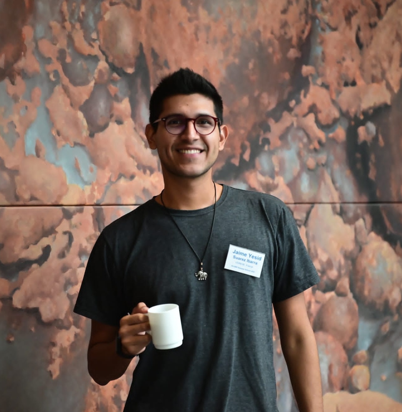 Me holding a coffee mug and smiling